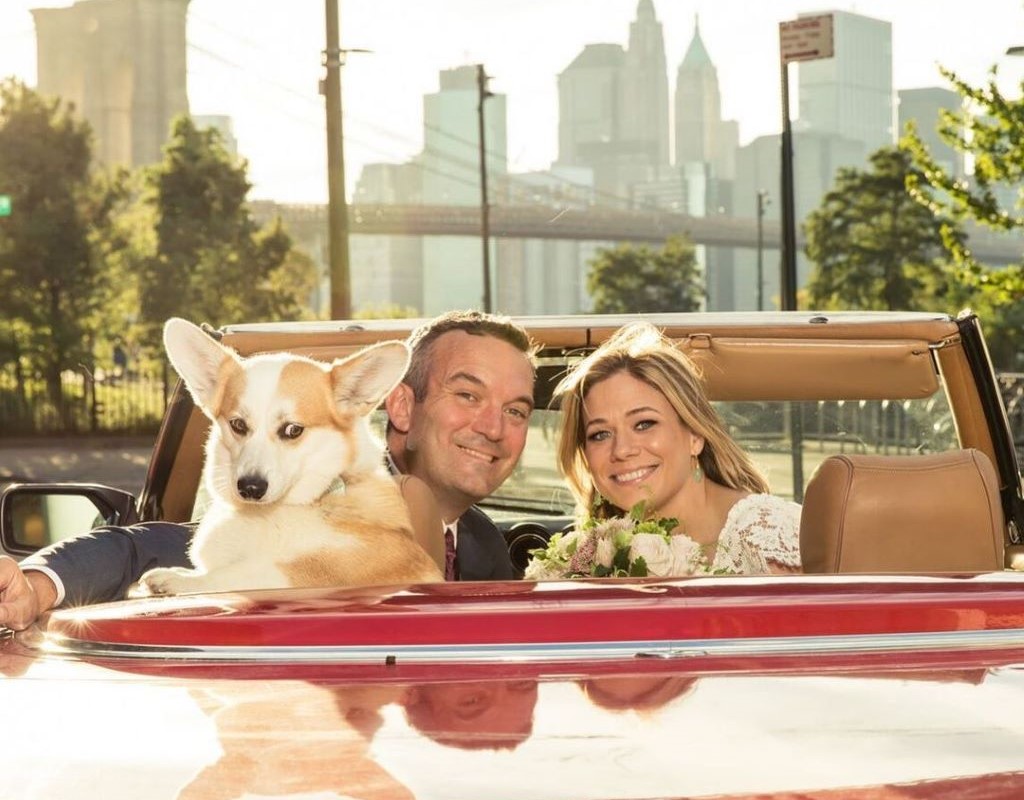 Elise and husband Mike in a vintage car during their wedding